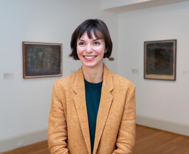 Clarisse Fava-Piz headshot in a gallery with art on the walls